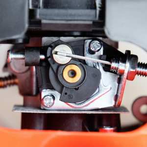 detalle del carburador de una desbrozadora donde se aprecia el cable del acelerador