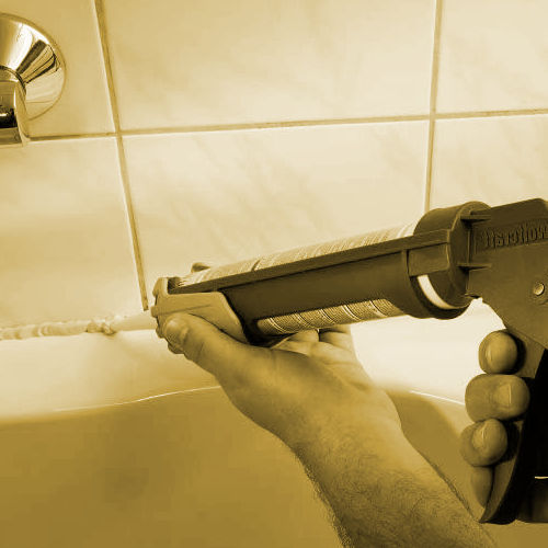 Selladores de silicona para ventanas, sanitarios de baños y cocinas manitas sellando la junta de la bañera y el azulejo en el baño de una vivienda